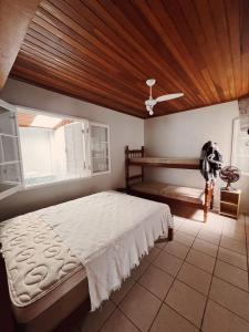 a bedroom with a bed and a wooden ceiling at Casa 50m do mar in Matinhos +41 photos