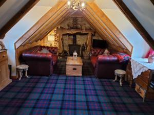 an attic living room with couches and a table at Traditional 2-Bed Cottage in Dalry in Dalry