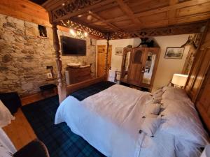 a bedroom with a large bed in a stone wall at Traditional 2-Bed Cottage in Dalry in Dalry