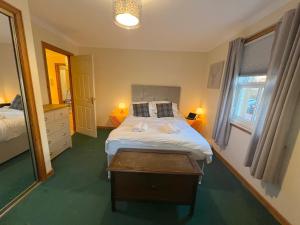a bedroom with a bed and a table in it at 16 Knightsridge House in Livingston