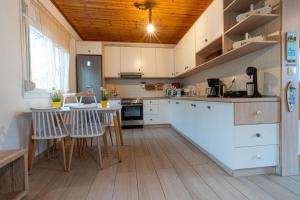 a kitchen with white cabinets and a table and chairs at Happy Family in Skala Kallirachis