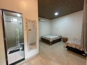 a room with two beds and a glass shower at Casa de Praia, em Belterra - PA in Belterra