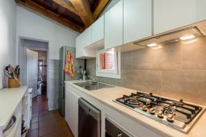 una cucina con piano cottura forno superiore accanto a un lavandino di Le Case di Mara - Appartamento Vista Mare a Porto Rotondo a Porto Rotondo