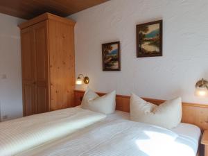 a bedroom with two beds and two lights on the wall at 2-Raum FeWo Arnika - Hallenbad & Sauna in Fischen +6 photos