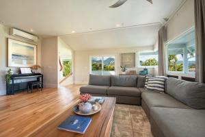 a living room with a couch and a piano at Hihimanu House in Princeville