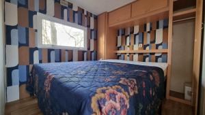 阿姆斯特丹City Farmer Farmyard Stays, Sleep Easy, Stay Rural, Explore Amsterdam的卧室里有一张床，上面铺着一条彩色毯子