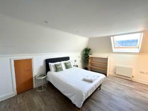 a bedroom with a white bed and a window at Addlestone - Large Stunning 2 bed room Apartment in Addlestone