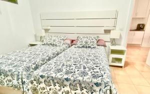 1 cama grande con edredón blanco y azul en Casa Valdes Los Cristianos Center, en Los Cristianos
