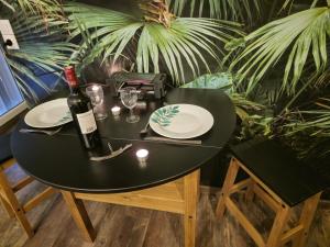 a black table with a bottle of wine and glasses at La Cabane in Châteauroux