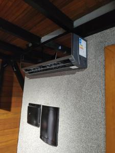 a kitchen counter with a microwave and two stools at Chales da Trilha in Penha
