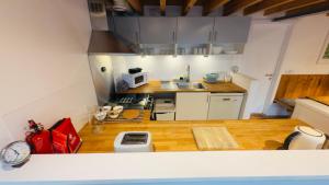 a small kitchen with a counter top with a clock at Afan Forest BunkHouse - Gallery Apartment in Glyncorrwg