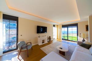 a living room with a white couch and a tv at Villa Seaside Shore in Budva