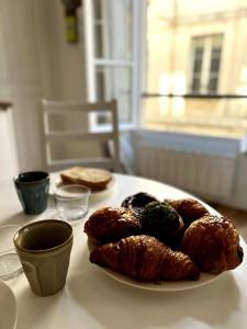 a table with a plate of pastries on a table at La Petite Paroisse Classé 3 étoiles Elégant & Proche Marché in Versailles