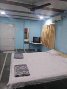 ムルドにあるGayatri holiday homeのベッドとテレビのある部屋