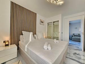 a bedroom with a large white bed with two pairs of shoes on it at Mareverde Dream in Costa de Adeje +26 photos