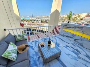 a balcony with a couch and a table with two bottles of wine at Mareverde Dream in Costa de Adeje