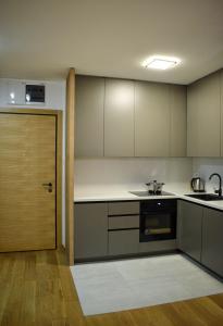 a kitchen with white cabinets and a door in a room at Atina 1 in Novi Sad