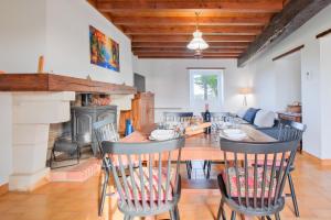une salle à manger avec une table et des chaises et une cheminée dans l'établissement Maison de Campagne, Grande Métairie, à Villetoureix