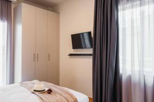 a room with a bed with a hat and a tv at Spacious seaside flat at alimos in Athens