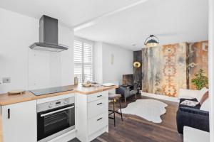 a kitchen with white cabinets and a counter top at Luxury Holiday Apartments in Torquay