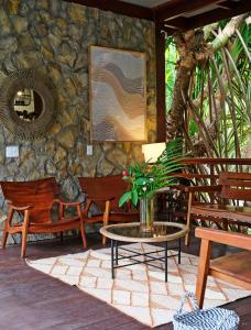 a patio with a table and chairs and a stone wall at Encantes do Nordeste in Barreirinhas +89 photos
