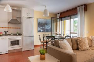a living room with a couch and a kitchen with a table at FGDR323H Las olas in San Vicente de la Barquera