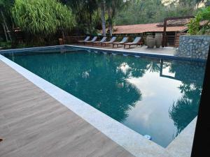 a swimming pool with some chairs and some water at Encantes do Nordeste in Barreirinhas