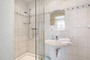 Un baño blanco con lavabo y ducha. en Ole Post, en Dagebüll 41 fotos más