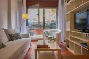 een woonkamer met een bank en een tv bij FGDR34BB El Puntal in San Vicente de la Barquera