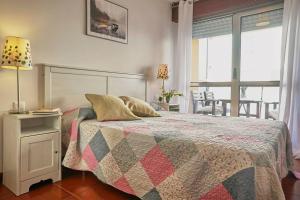 een slaapkamer met een bed met een dekbed erop bij FGDR342E La Playona in San Vicente de la Barquera