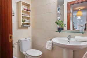 een badkamer met een wit toilet en een wastafel bij FGDR342E La Playona in San Vicente de la Barquera +33 foto's