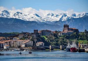 een stad met besneeuwde bergen op de achtergrond bij FGDR342E La Playona in San Vicente de la Barquera