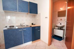 una piccola cucina con armadi blu e lavandino di Studio apartments M&N a Trogir Altre 42 foto