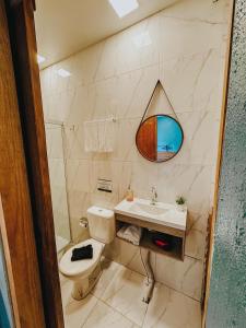 a bathroom with a sink and a toilet and a mirror at Espaços Cardoso, AURORA - luz e leveza in Igrejinha +20 photos