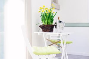 ein weißer Tisch mit einem Korb mit Blumen drauf in der Unterkunft Deluxe Apartments LWP7 in Baden-Baden