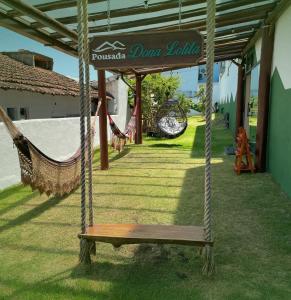 a porch with a hammock and a sign that reads pocomokeouloul at Pousada Dona Lolita in Cachoeira Paulista