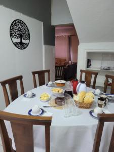 a table with a white table cloth with food on it at Pousada Central in Bragança Paulista