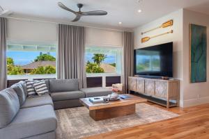 a living room with a couch and a tv at Hihimanu House in Princeville