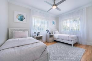 a bedroom with two beds and a ceiling fan at Hihimanu House in Princeville