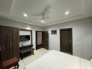 a living room with wooden cabinets and a television at Hotel Pearl inn in Rudrapur
