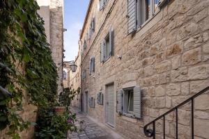 an alley in an old town with stone buildings at Forkira Luxury Hvar in Hvar