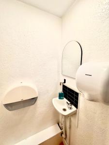 a white bathroom with a sink and a mirror at London Collection - Bayswater in London