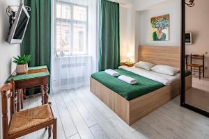 Schlafzimmer mit einem Bett mit grüner Bettwäsche und einem Spiegel in der Unterkunft Apartment on Virmens`ka Street in Lwiw