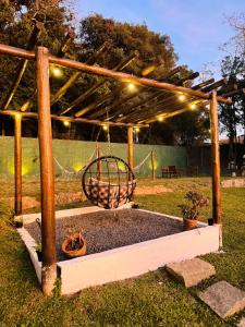 a pergola with a swing in a yard at Pousada Bosque in Monte Verde