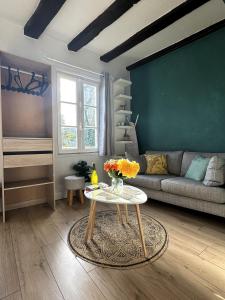 a living room with a couch and a table at Côté Cathédrale - Grand studio Rue du Salé - Centre Historique in Quimper