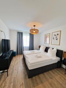 a bedroom with a bed and a flat screen tv at ARGENTA Living 129 in Künzell