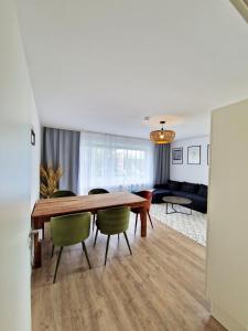 a dining room with a wooden table and green chairs at ARGENTA Living 129 in Künzell