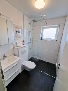 a white bathroom with a sink and a toilet at ARGENTA Living 129 in Künzell