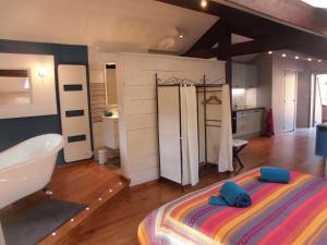 Un dormitorio con una cama, una bañera y un lavabo. en La Sauvanière, en Menée