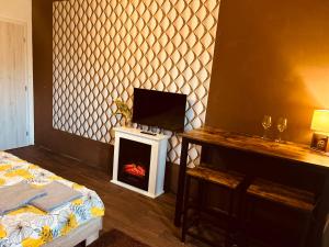 a room with a bed and a tv and a fireplace at Apartment Pharamis in Bešeňová